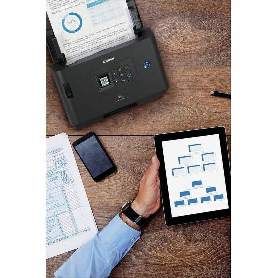 Sure, here is the corrected and grouped text from the image:

---

**Top Left:**

- Breakdown of operations by 50%

**Top Right:**

- Canon

**Bottom Left:**

- (Text on the paper is not fully legible, but it appears to be a form or document with various sections and checkboxes.)

**Bottom Right:**

- (Diagram on the tablet screen, likely a flowchart or organizational chart, with blue boxes connected by lines.)

---

If you need more specific details or corrections, please let me know!