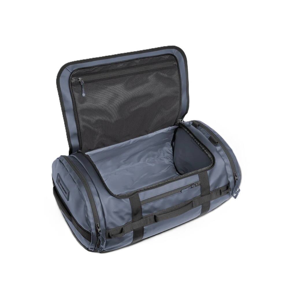 Angle. WANDRD - WANDRD CARRYALL 60L Duffel Bag - Rugged Travel and Gear Hauler (Aegean Blue) - Blue.