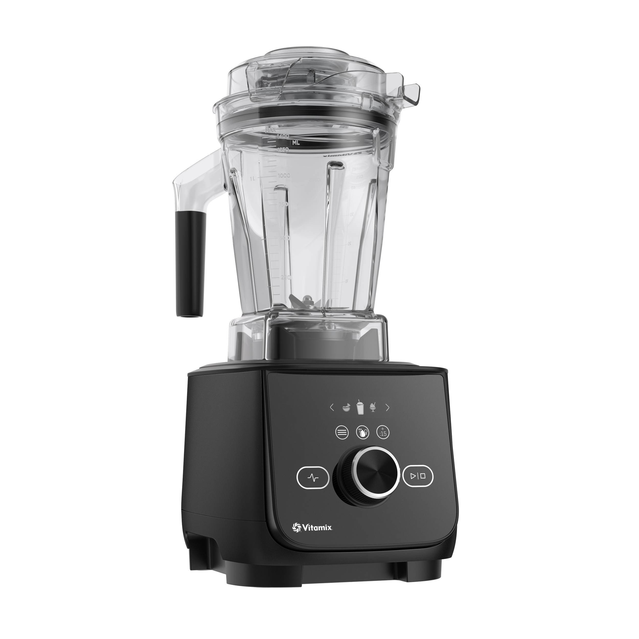 The image shows a Vitamix blender with a black base and a clear container. The blender is turned on and ready to blend.