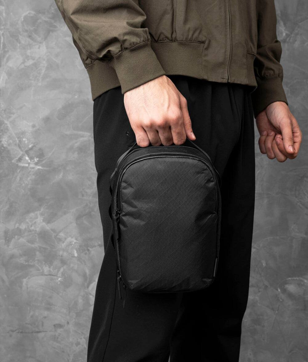 Left. ALPAKA - Metro Sling Max 3L Crossbody Sling Bag, Fits iPad Mini/Switch/Headphones, YKK AquaGuard Zippers - Black Ultradyne 100D.