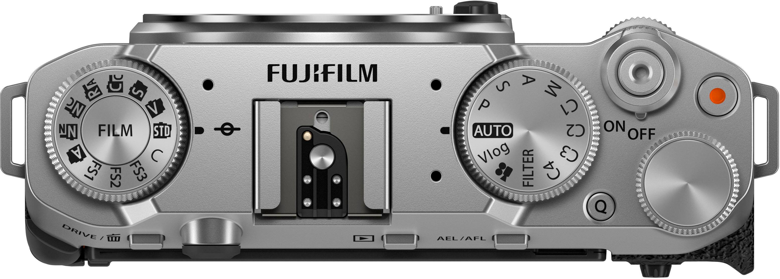 Fujifilm camera with a silver body and black dials. The camera has a film standard setting and an auto drive setting. There are also several other settings, including a vlog setting, a filter setting, and a C3 filter setting. The camera also has a C4 setting for Q AEL/AFL.