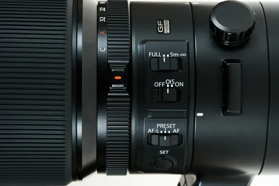 The image features a close-up view of a camera lens, with the largest text reading "FUJINON." The lens has a variety of buttons and settings, including "Full," "OIS," "OFF," "ON," "PRESET," "AF-L," and "AF SET." The lens is designed for use with a Canon camera.