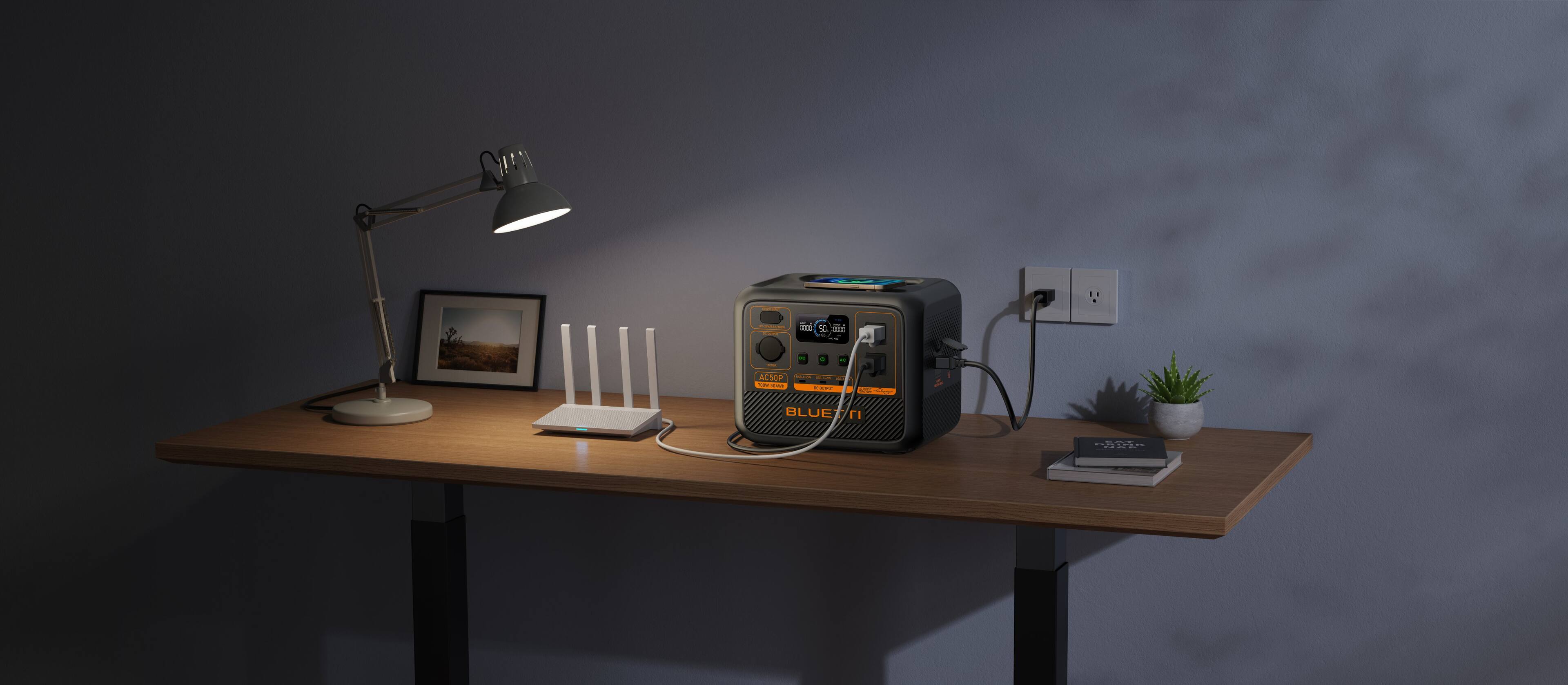 The image shows a desk with a lamp, a computer, a cell phone, and a potted plant. The lamp is turned on, and the desk is illuminated by the light. The computer is placed on the desk, along with a cell phone and a potted plant. The desk appears to be a workspace, and the items on it suggest that it is used for various tasks, such as work, communication, and relaxation.