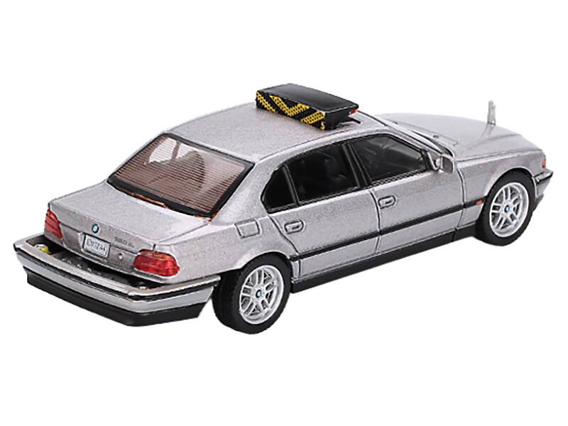 Left. Mini GT - BMW 750IL Gray Metallic 007 James Bond "Tomorrow Never Dies" (1997) Movie Limited Edition 1/64 - Gray Metallic.