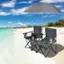 A pair of chairs on the beach with an umbrella.