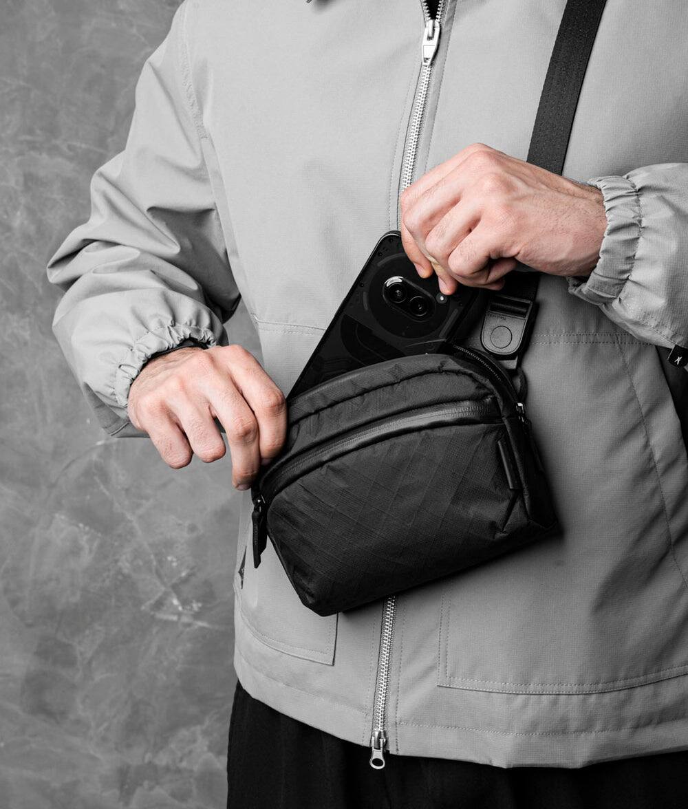 Alt View 2. ALPAKA - Flight Sling 1L Travel Sling Bag, Lightweight Crossbody Pouch, Phone Sleeve, Passport Pocket, Detachable Strap - Black Ultradyne 100D.