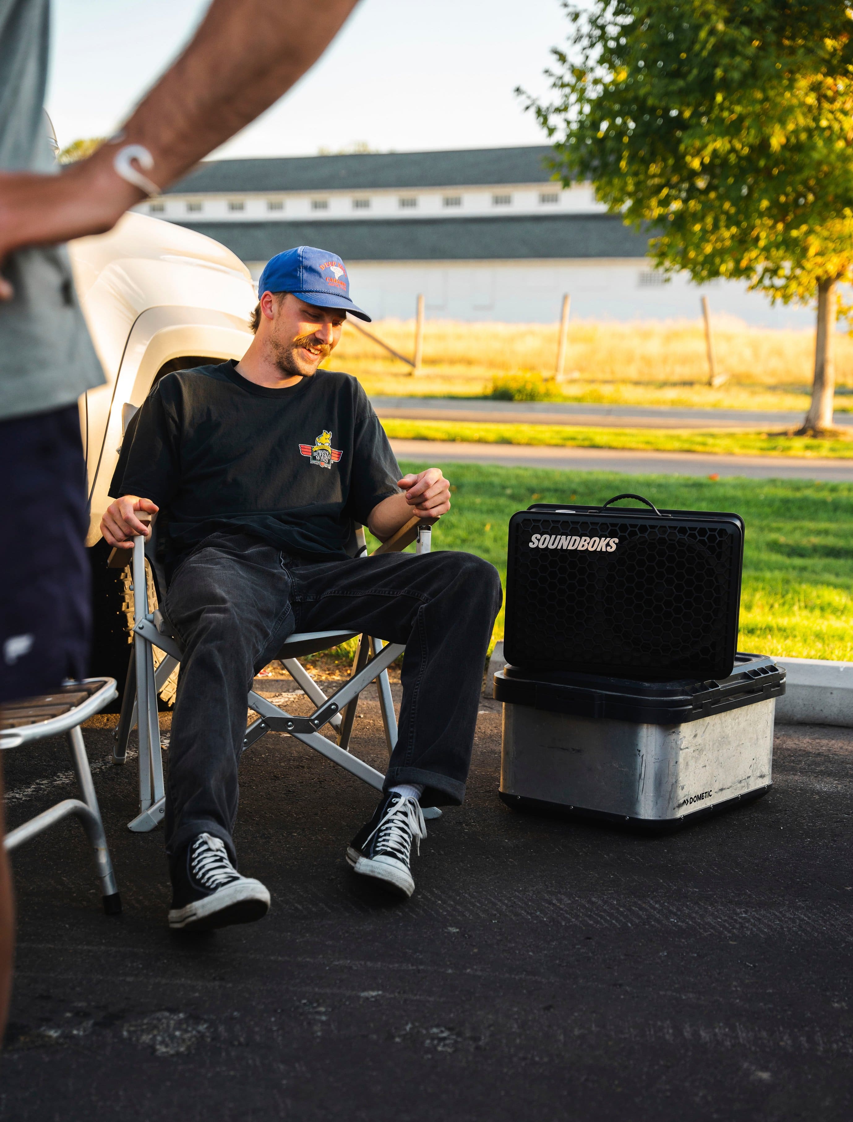 The man is sitting in a chair next to a sound system.