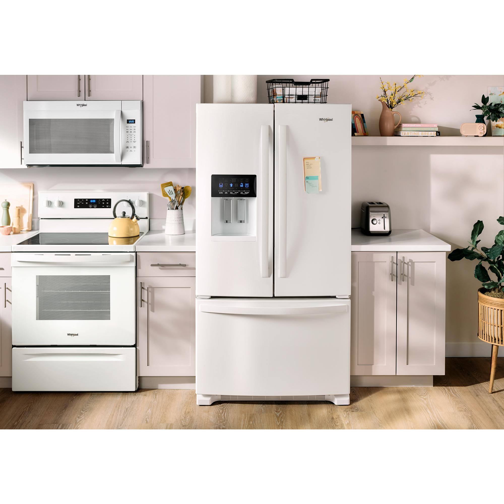 The image features a kitchen with a refrigerator and a microwave. The refrigerator is located next to the microwave, and there is a counter nearby. The kitchen also has a stove and an oven, which are placed close to each other. Additionally, there are several books and a potted plant in the kitchen, adding to the overall ambiance.