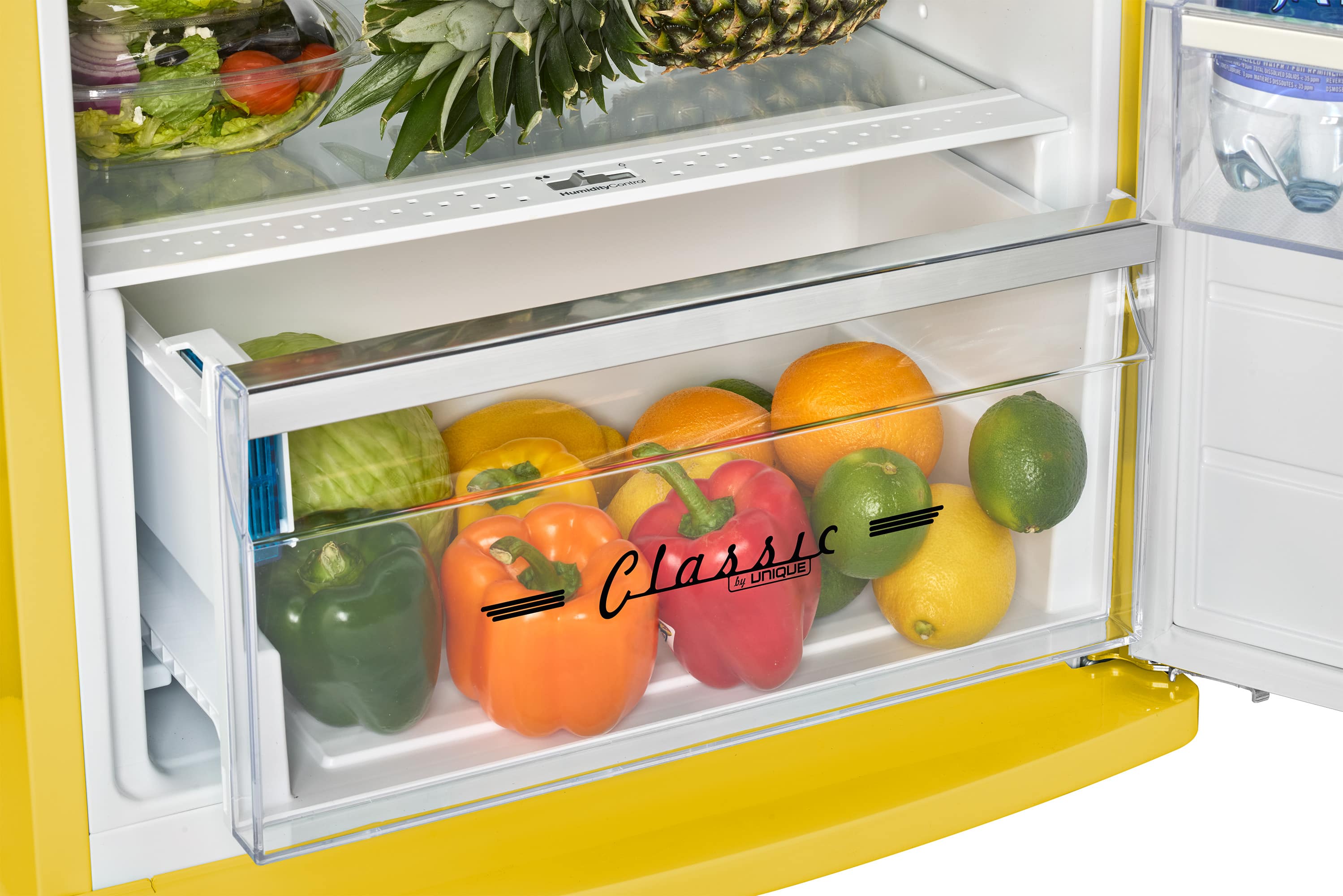 A yellow refrigerator with a drawer labeled "Classic" filled with various fruits and vegetables, including apples, oranges, and bananas.