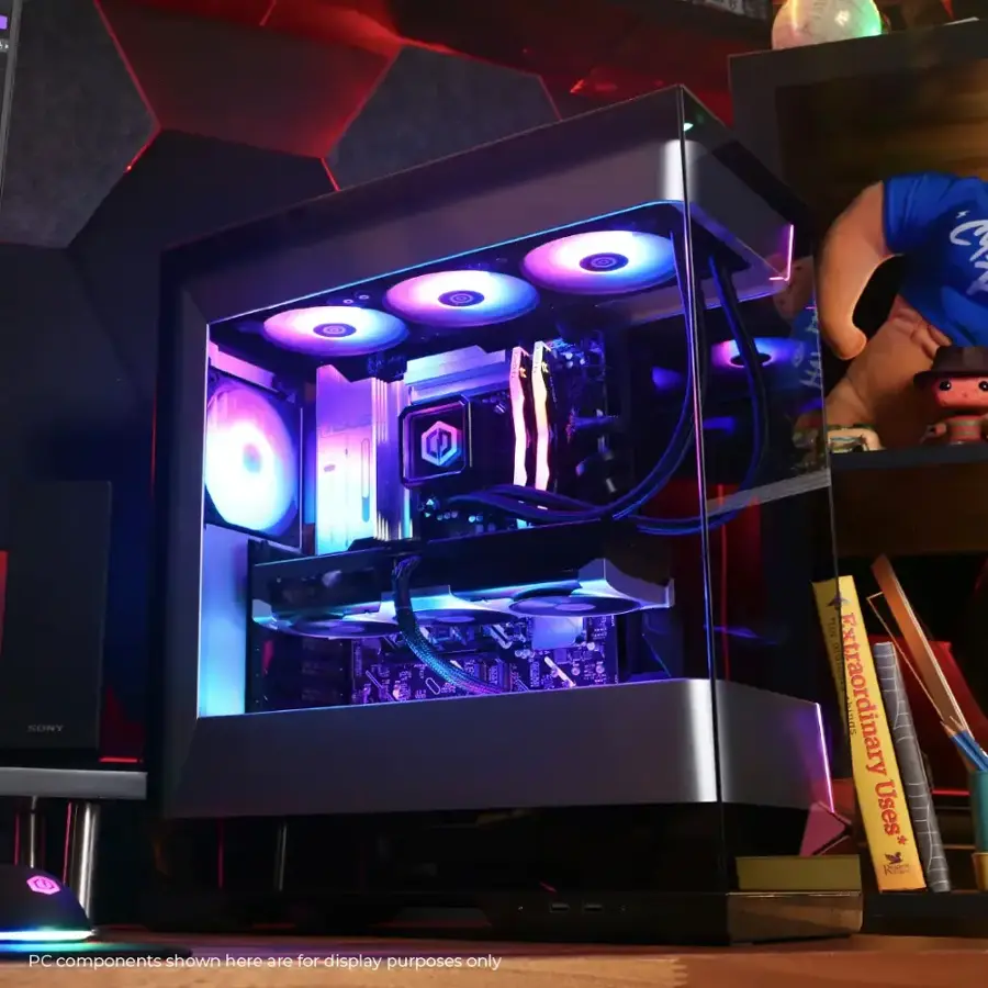 The image features a computer tower with a blue light inside. The tower is surrounded by various books and a person is visible in the background. The image is likely showcasing the computer tower and its components for display purposes.