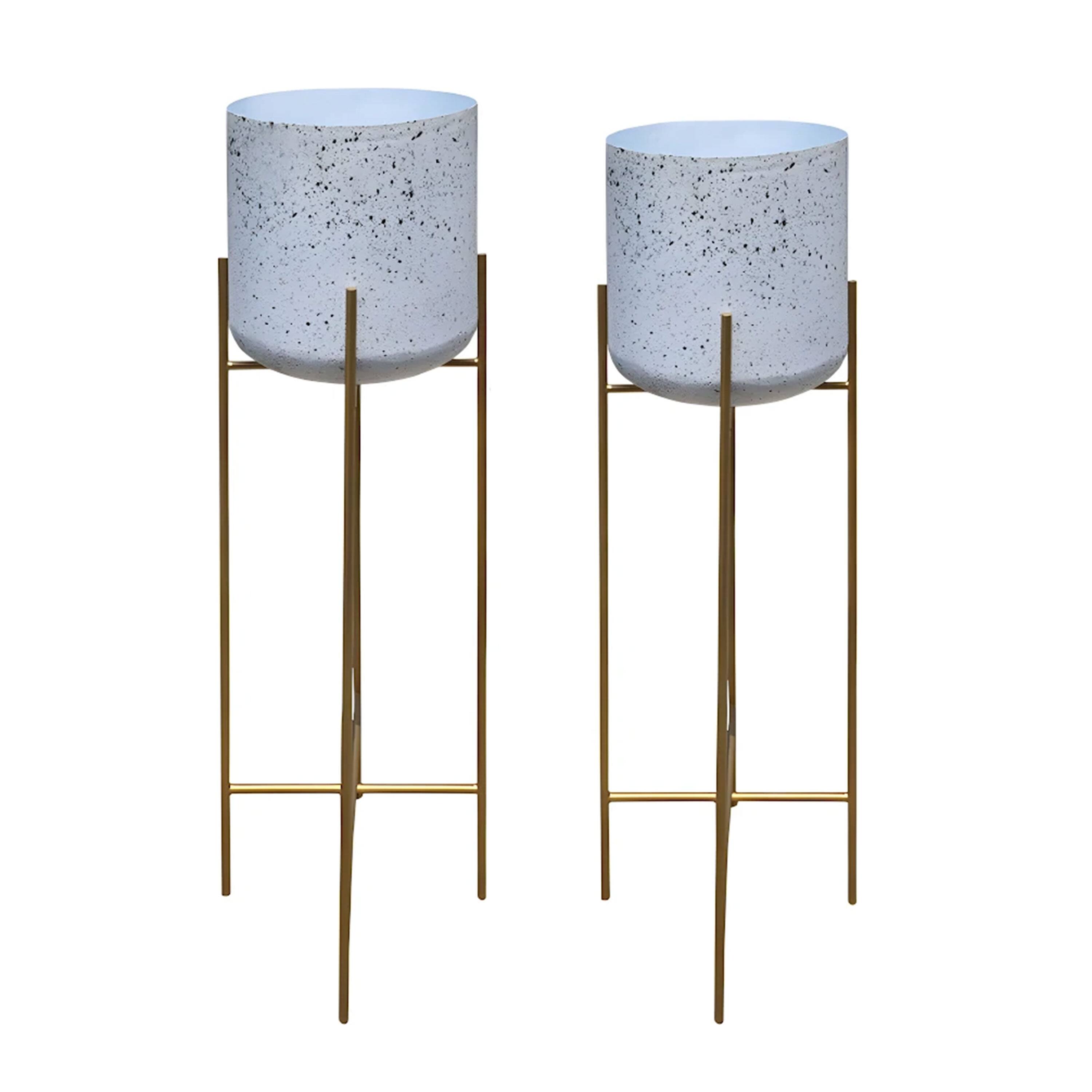 Left. Manhattan Lane - Aira Set of 2 Planters | 20, 22" Tall | Gold Foldable Metal Stand | White Speckled Pattern.