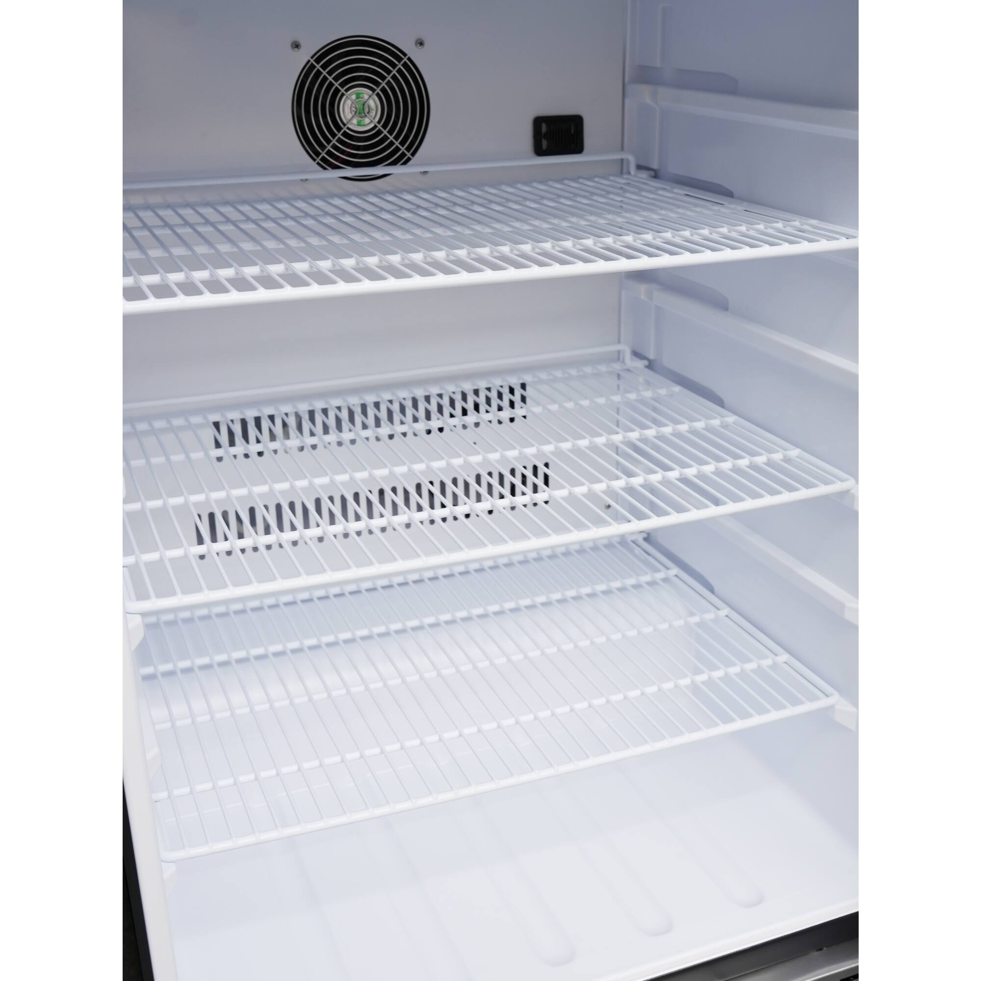 The refrigerator is empty and has a fan on the top.