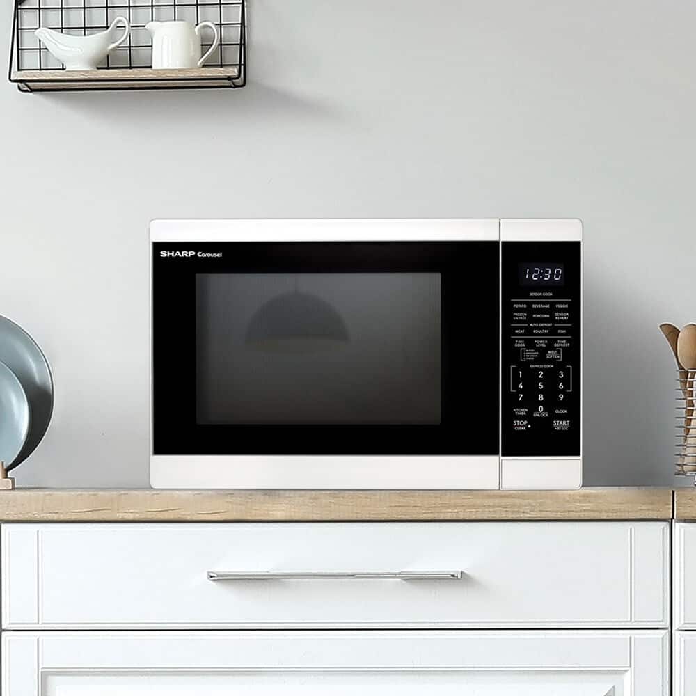 The image features a white microwave sitting on top of a wooden counter. The microwave is turned on, and the time displayed on the screen is 2:30.