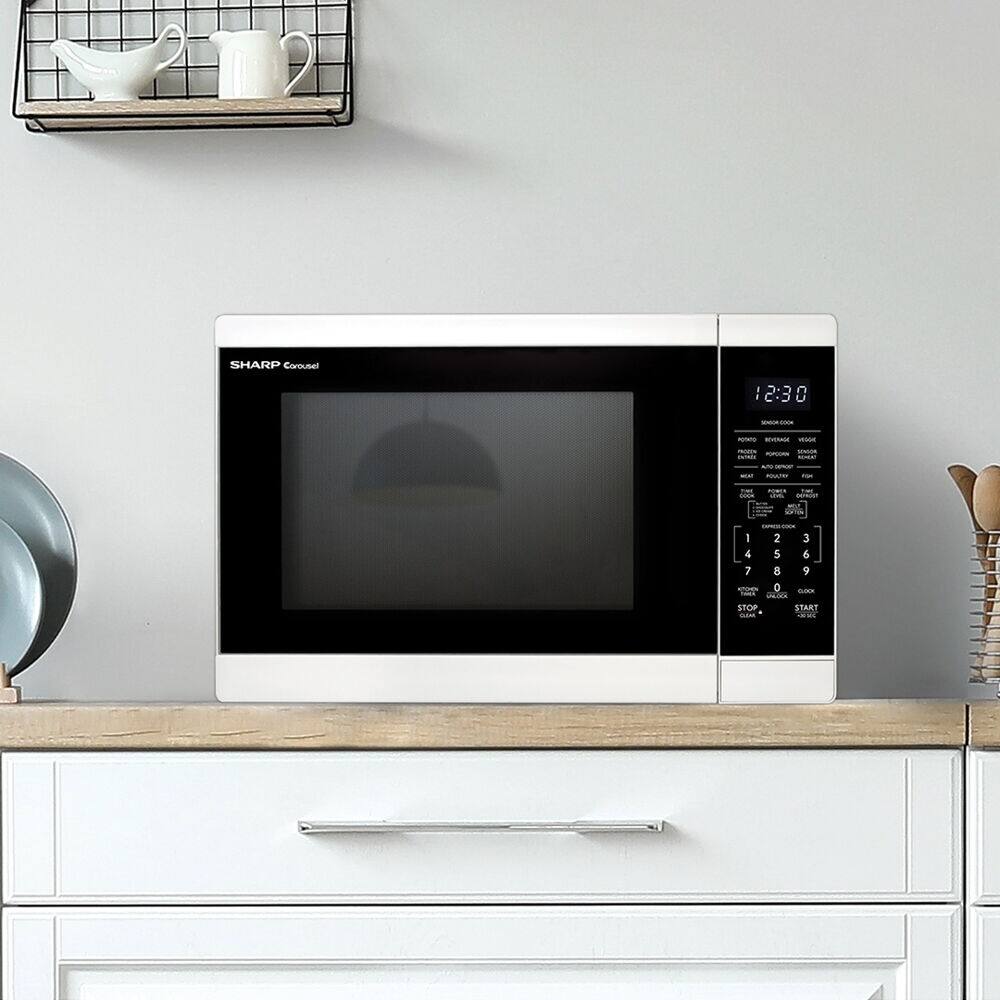The image features a white microwave sitting on top of a wooden counter. The microwave is turned on, and the time displayed on the screen is 2:30.