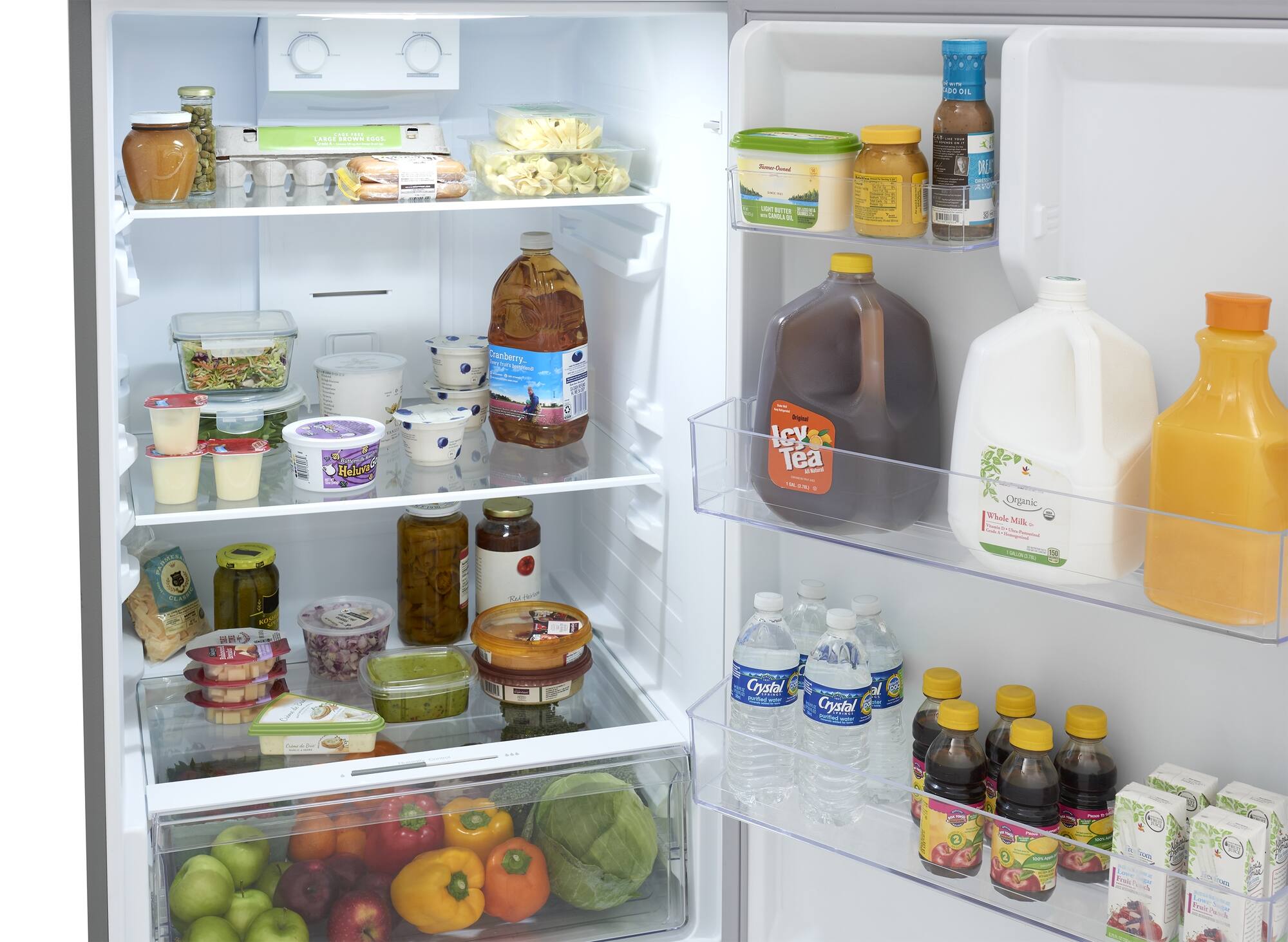 The refrigerator is well stocked with a variety of food and drinks. There are several bottles of drinks, including milk and juice, placed on the shelves. Additionally, there are multiple bottles of oil and condiments, such as ketchup and mustard, which can be used for cooking or adding flavor to dishes. The refrigerator also contains a variety of fruits, including apples and oranges, as well as vegetables like broccoli. The assortment of food and drinks in the refrigerator indicates that it is well-prepared for meal preparation and consumption.