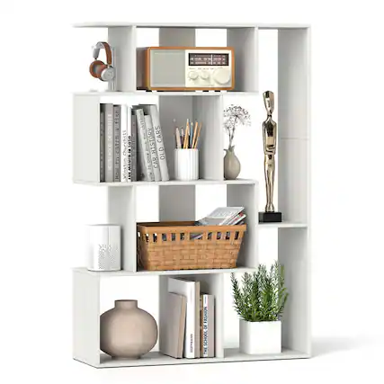 The image features a white bookshelf filled with various items. There are several books of different sizes and colors, as well as a radio placed on the top shelf. A vase is located on the middle shelf, and a potted plant is placed on the bottom shelf. Additionally, there is a statue on the top shelf, and a pair of scissors can be found on the middle shelf. The bookshelf is organized neatly, making it an attractive and functional display.