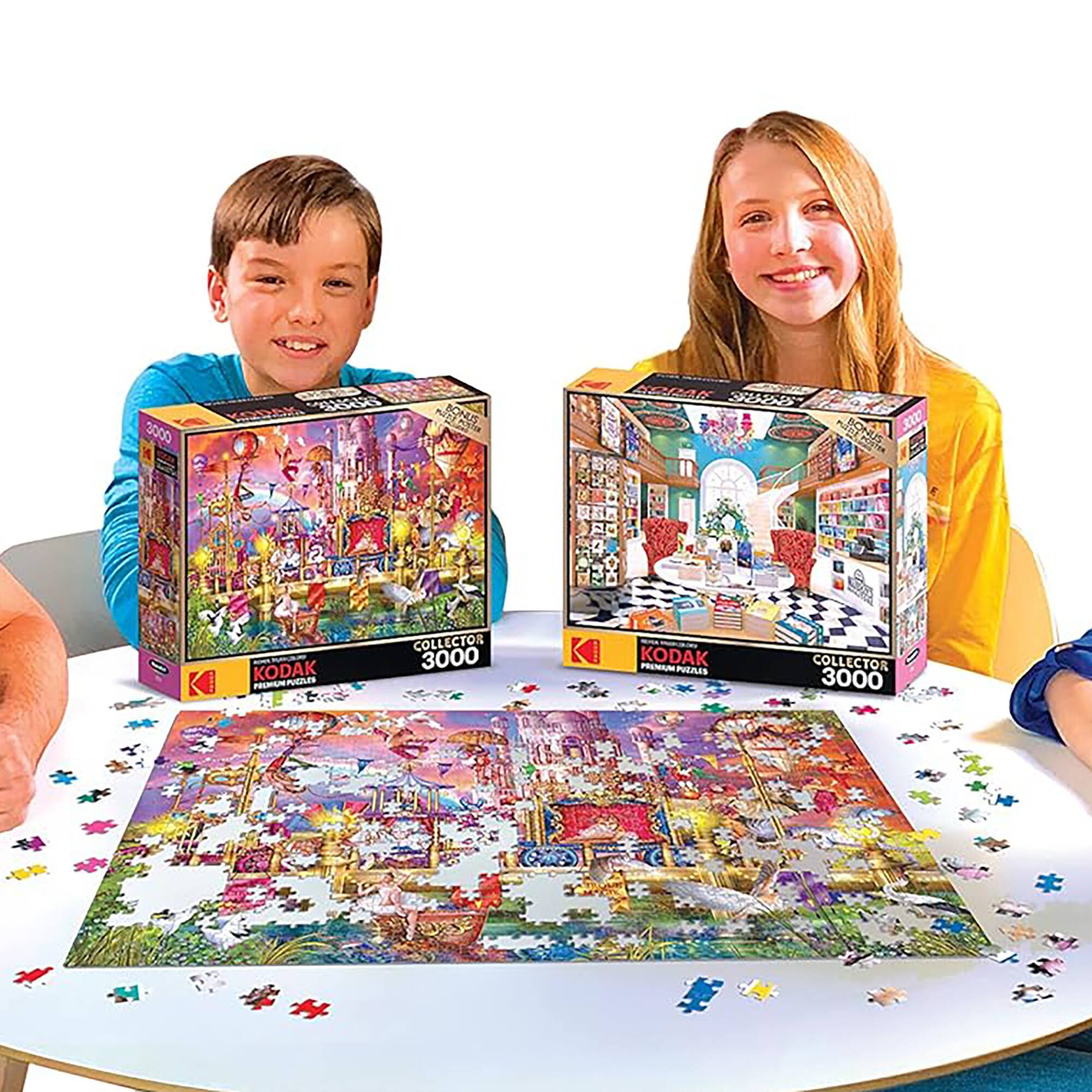 The image shows three children sitting at a table with two puzzles in front of them. The children are posing for a picture, and they are smiling. The puzzles are Kodak branded, and they are both 3000 pieces. The children are enjoying their time together, and the puzzles are likely a source of entertainment and challenge for them.