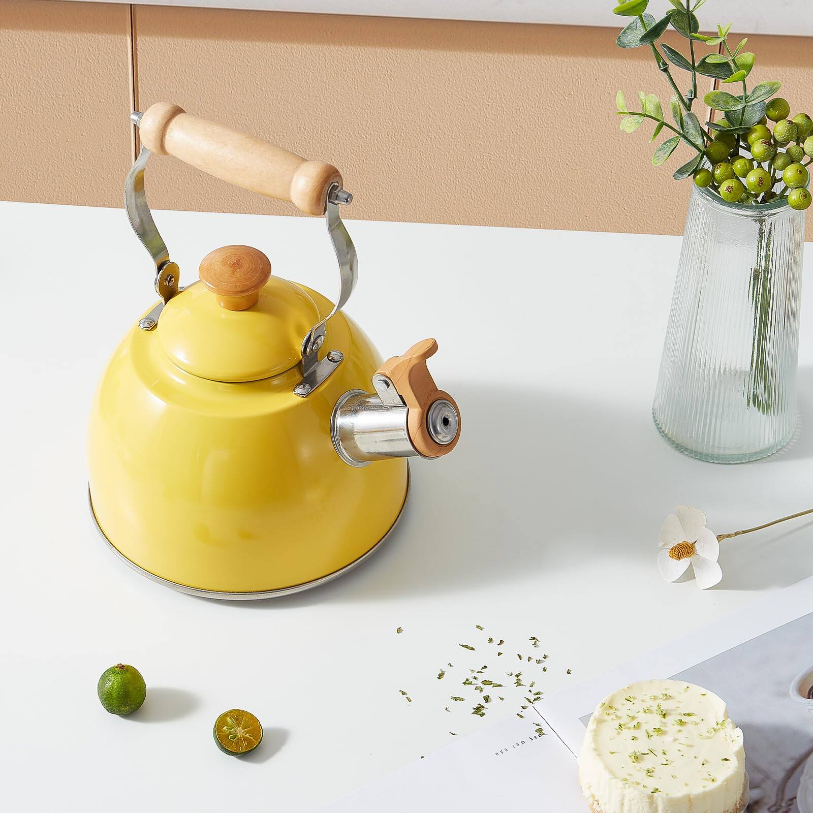 The image does not contain any text to group or correct. It shows a yellow coffee grinder, a cake with green garnish, and a vase with green berries.