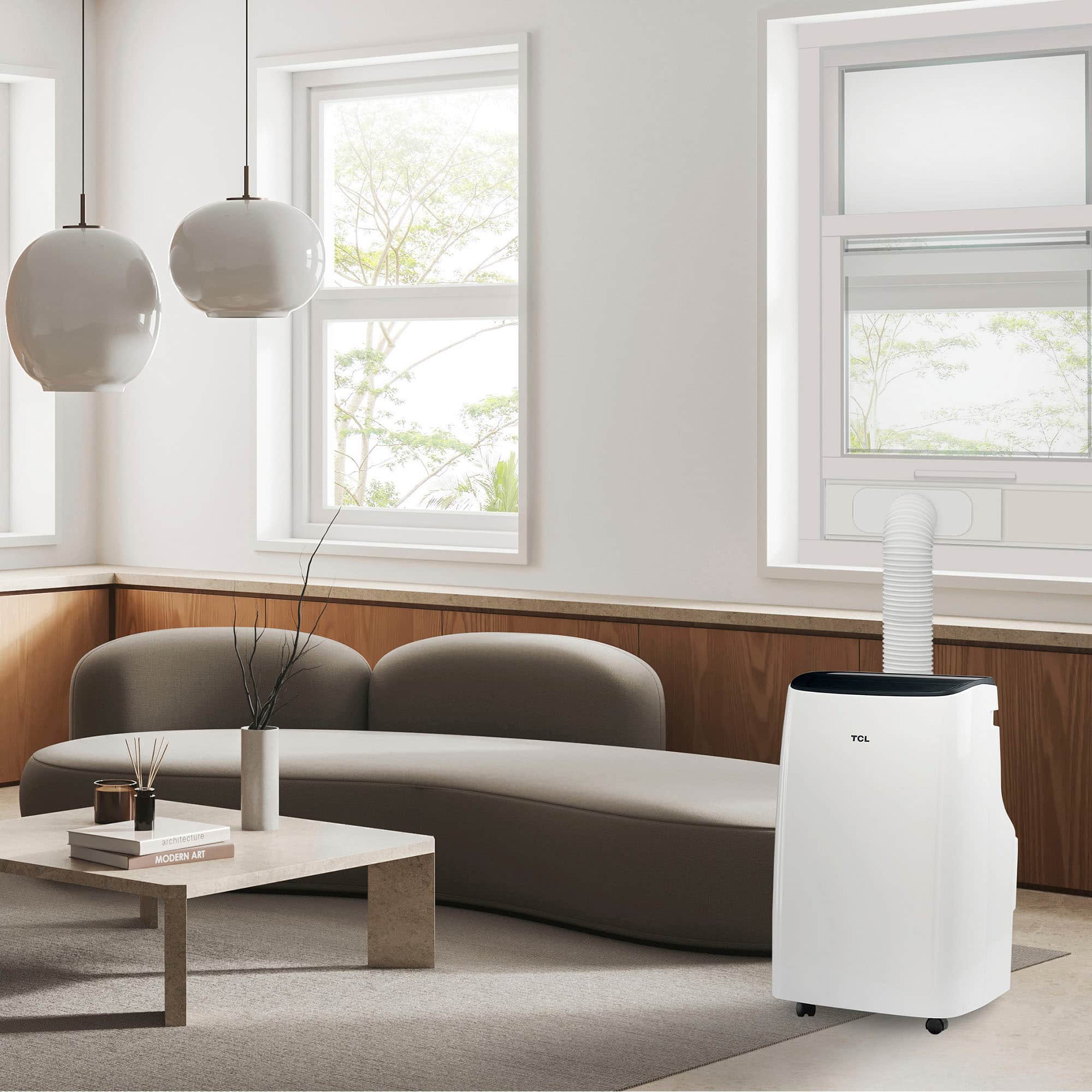 The image features a modern living room with a large window, allowing natural light to fill the space. The room is furnished with a couch, a coffee table, and a book. A vase is placed on the coffee table, adding a touch of elegance to the room. A large white air purifier is also present in the room, ensuring clean air and a comfortable environment. The overall design and layout of the living room showcase a contemporary and stylish aesthetic.