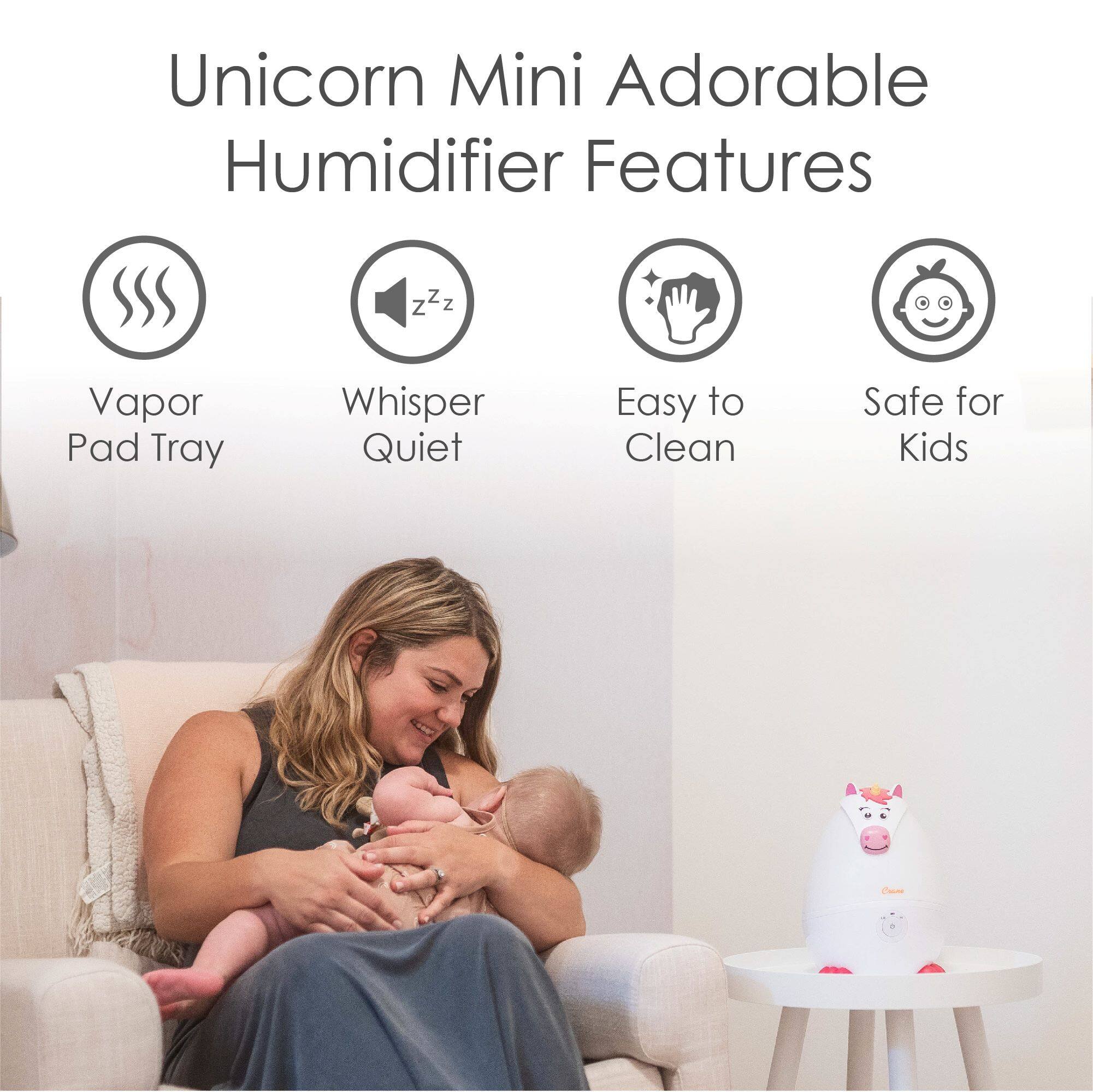 The image features a woman sitting in a chair, holding a baby. In the background, there is a humidifier with a unicorn design. The humidifier has several features, including a vapor pad tray, a whisper quiet operation, easy cleaning, and safety for kids. The woman appears to be enjoying her time with the baby, and the humidifier provides a comfortable environment for both of them.