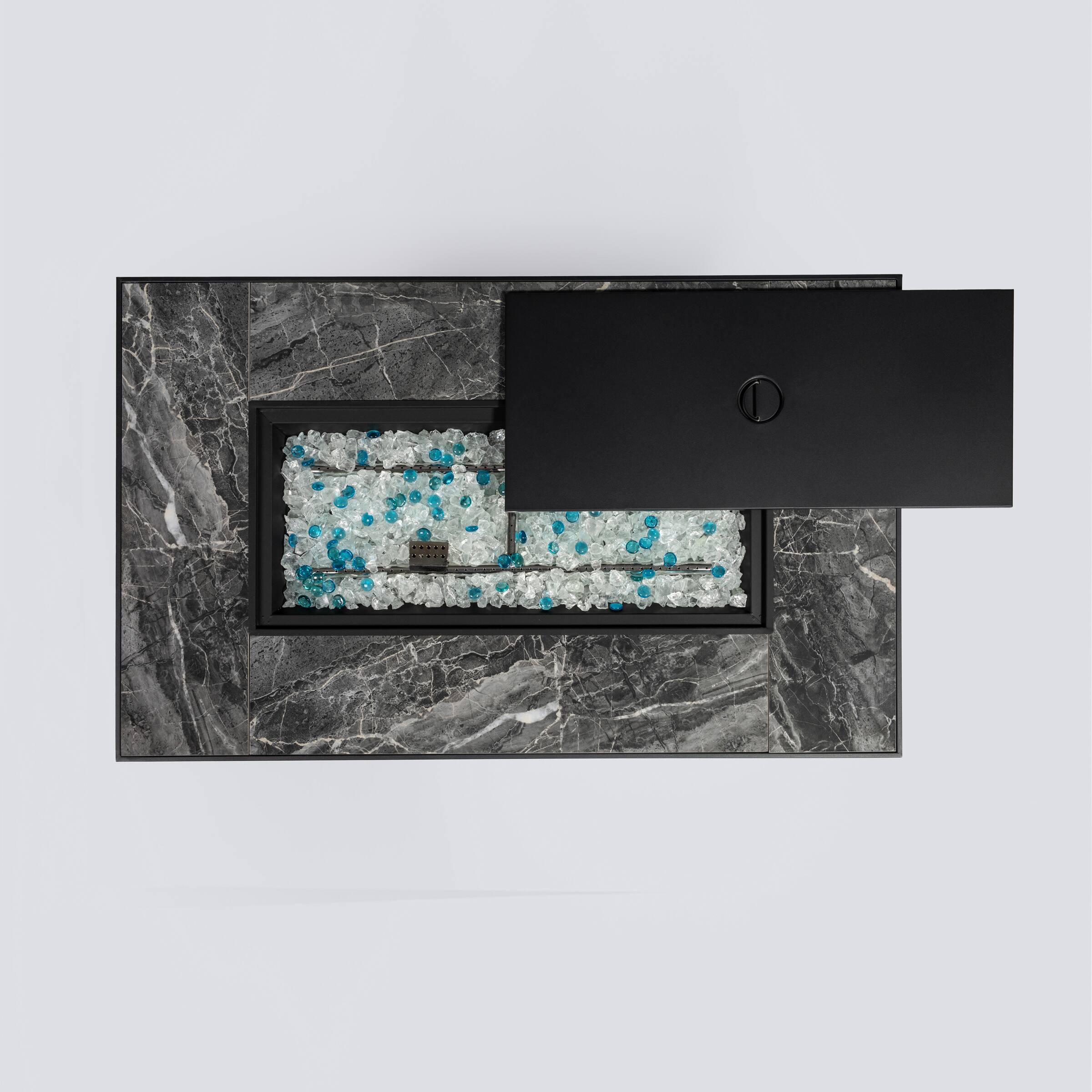 The image shows a luxurious jewelry box with a marble exterior and a black interior. Inside, there are two compartments filled with ice-like crystals and blue gemstones. The box has a sleek, modern design with a black lid featuring a circular logo.