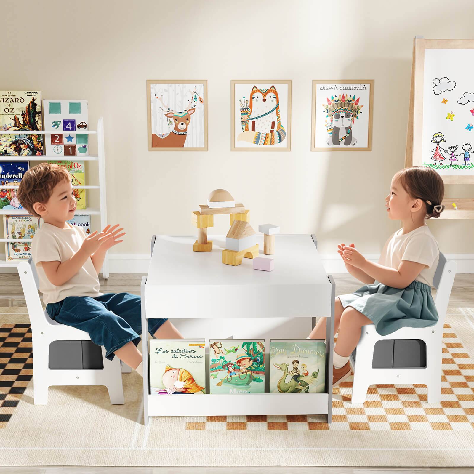 The image shows two children sitting at a table in a room. They are surrounded by various books, which are placed on the table and nearby. The children are engaged in a conversation or activity, possibly discussing the books or sharing their thoughts about them. The scene suggests a cozy and comfortable environment where the children can enjoy reading and interacting with each other.