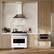 The text on the image is "D ELIE I SUNE D ZLNI." However, it is not clear what this text represents or its relevance to the image. The image features a kitchen with a stove, oven, and refrigerator, along with a counter and a potted plant.
