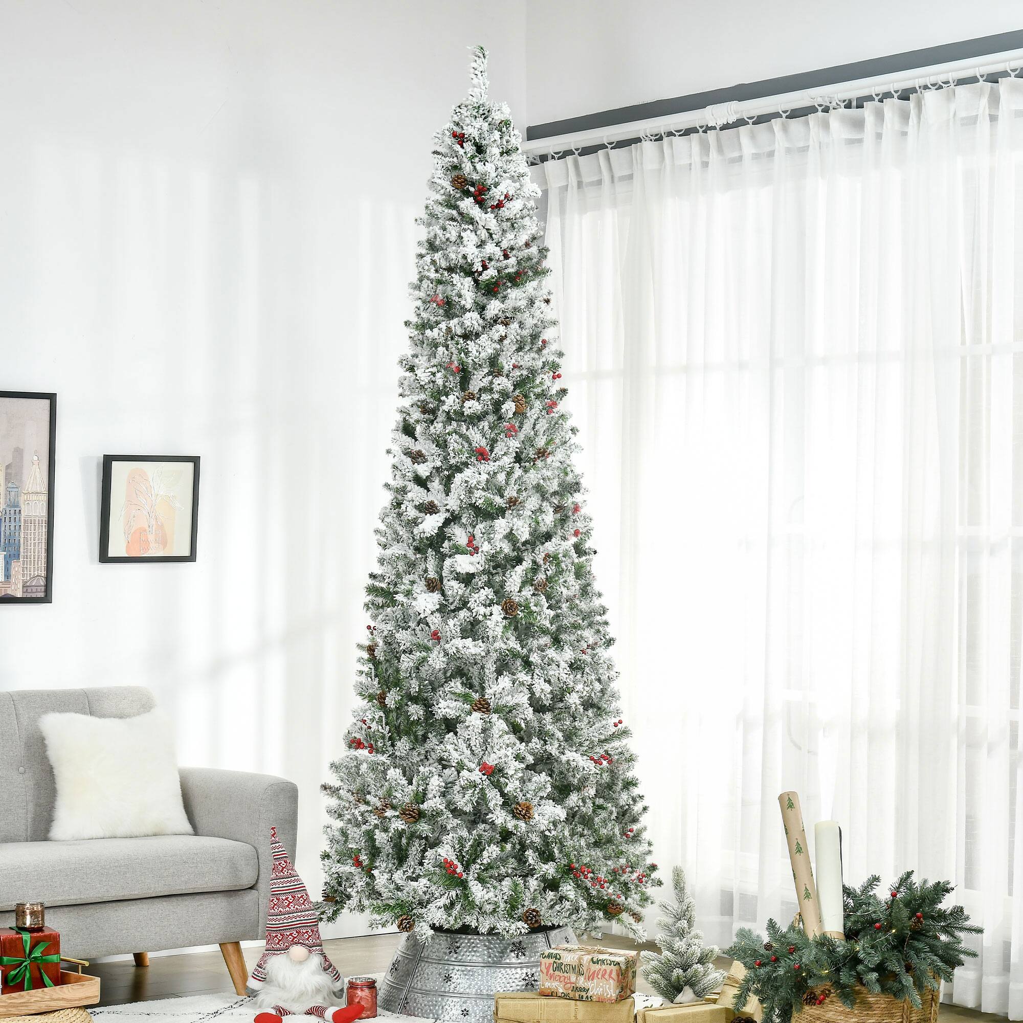 A 5-foot artificial Christmas tree with a white, snow-covered appearance and red berries is set up in a cozy living room.