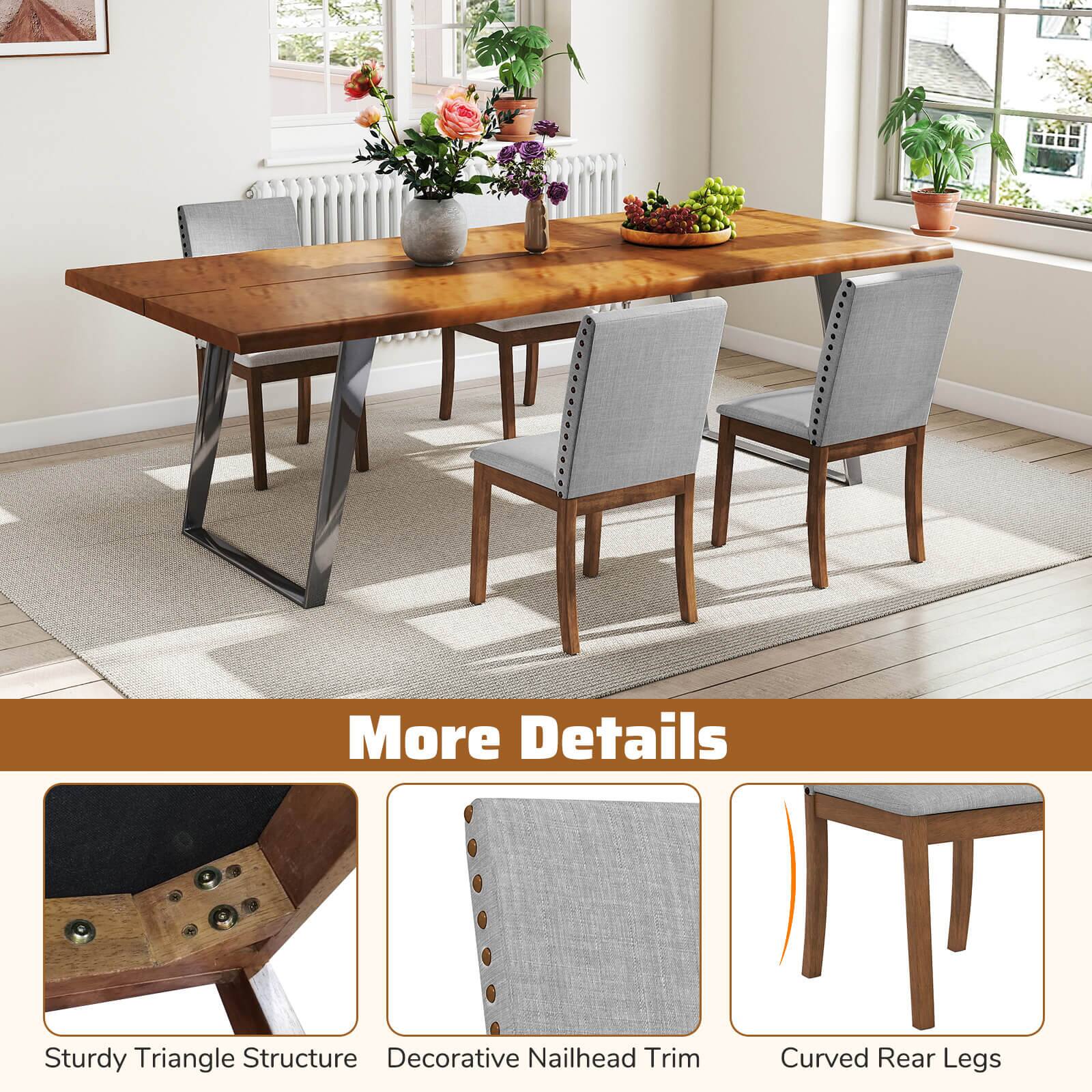 The image features a wooden dining table with chairs around it. The table is set with various items, including a vase of flowers, a bowl of fruit, and a potted plant. The table is accompanied by a bench, and the chairs have a decorative nailhead trim. The table is described as having a sturdy triangle structure, and the chairs are said to have curved rear legs.