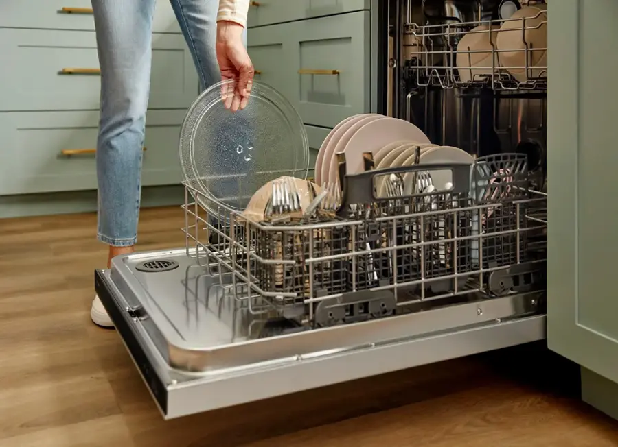 The text "220 whirbel" is not present in the image. The image shows a kitchen with a microwave on a counter, a sink, and various items such as a potted plant, a vase, and a knife.