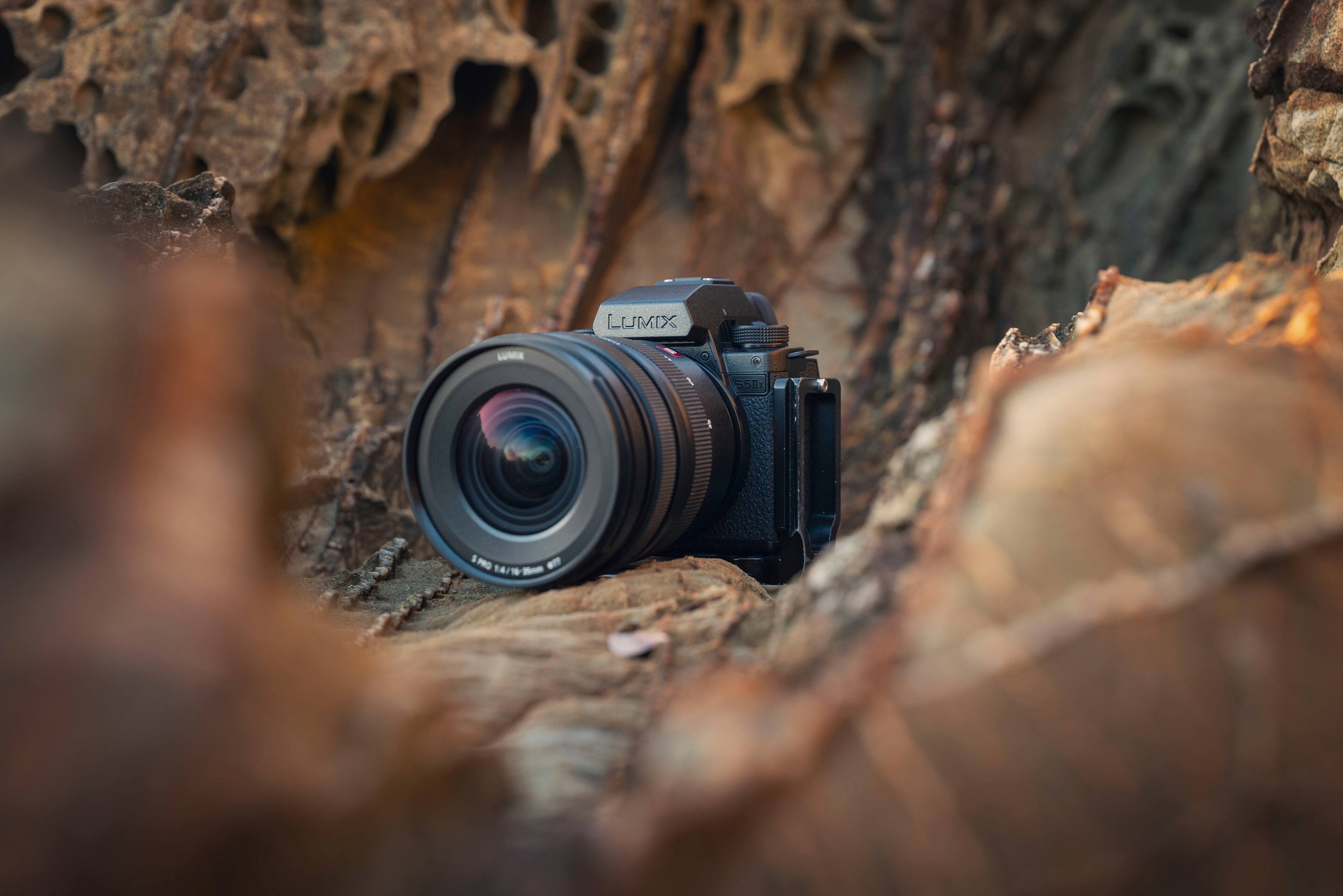 Lumix Luna 550 P0 is a camera that is sitting on a rocky surface.