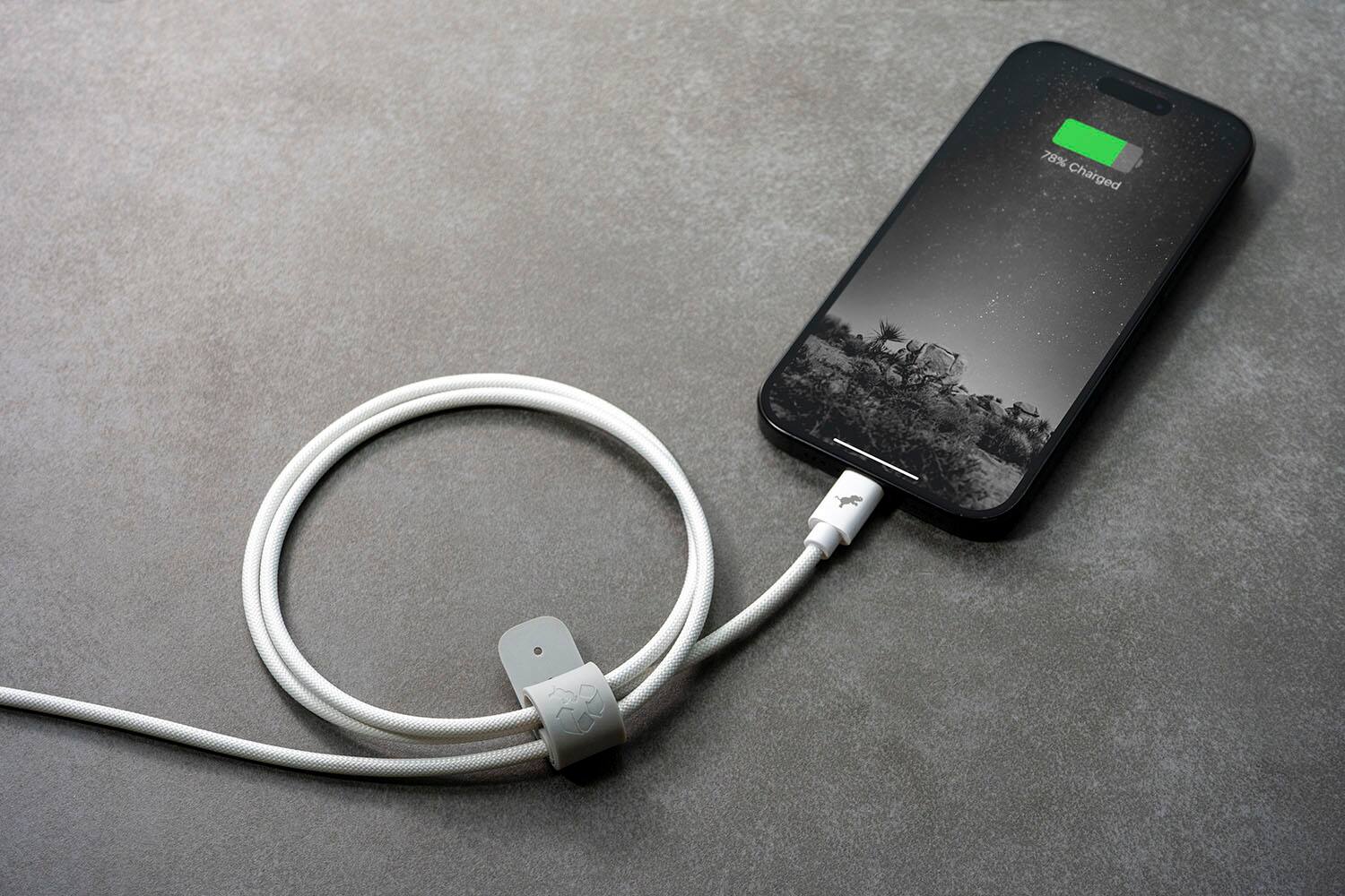 The image shows a cell phone that is 78% charged. The phone is connected to a charger, which is plugged into an outlet. The phone is sitting on a table, and the charger is positioned next to it.