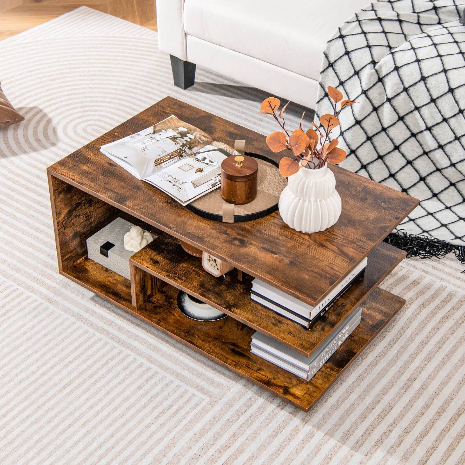 I cannot group or correct the text as it does not appear to be related to the image. The image shows a wooden coffee table with a vase of flowers on top, a stack of books, and a remote control. There is also a white couch in the background.