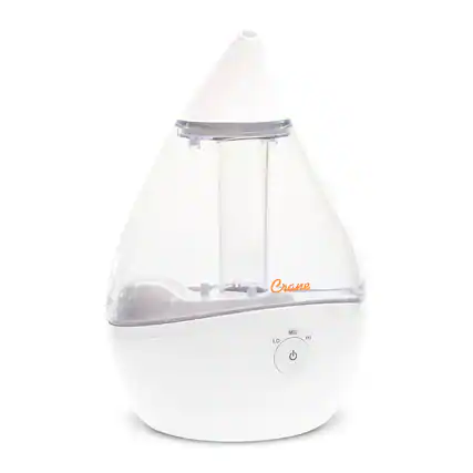 The image features a white Crane humidifier, which is designed to provide a comfortable humidity level in the room. The humidifier has a clear glass container, allowing users to see the water level inside. It is equipped with a control panel that allows for easy adjustment of the humidity level, with options for low, medium, and high settings. The humidifier is placed on a white surface, and its sleek design and modern appearance make it an attractive addition to any living space.