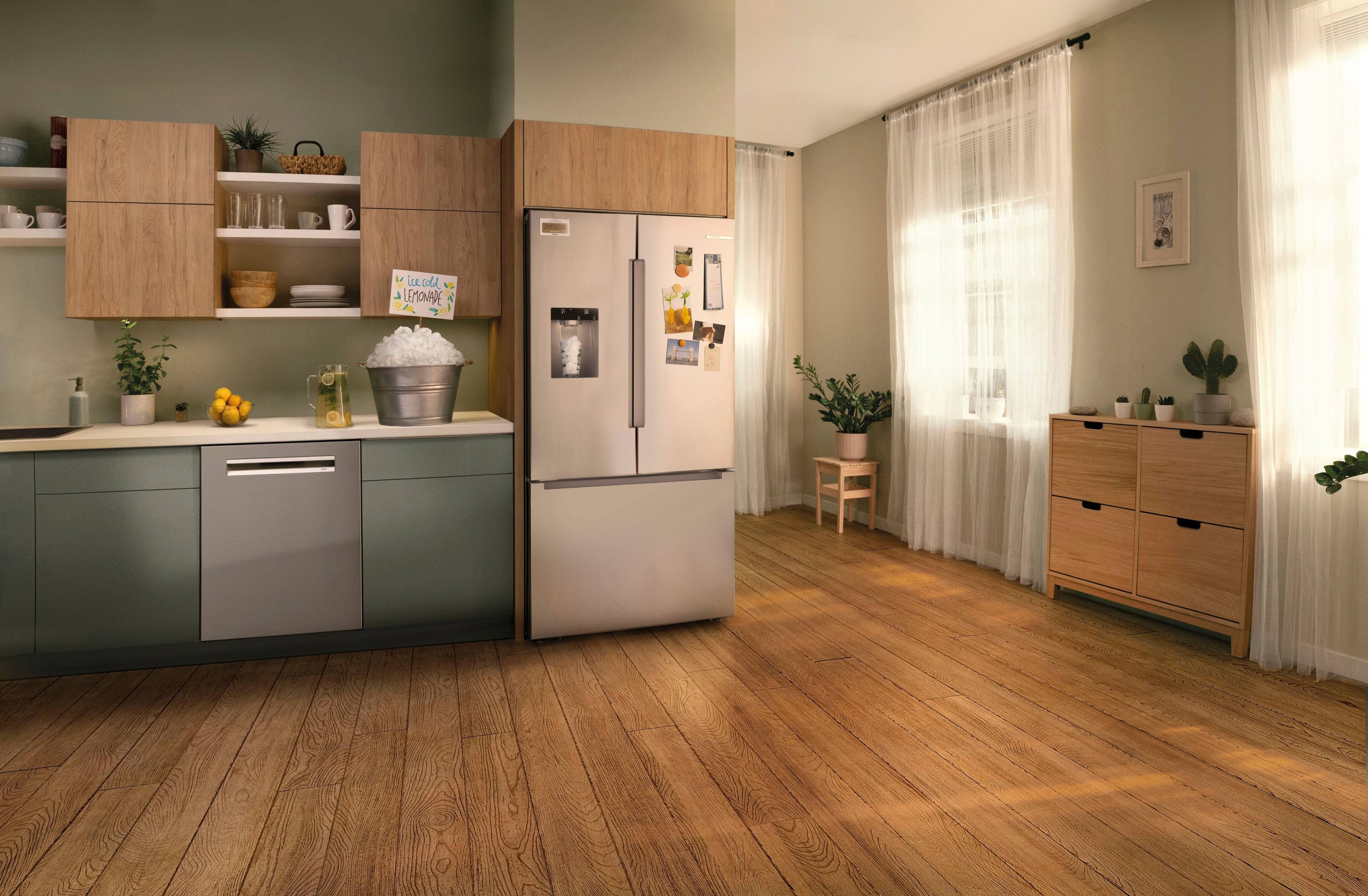 The image shows a kitchen with a refrigerator, sink, and cabinets. There are also several potted plants in the room, and a vase on the counter. The refrigerator is positioned between the sink and the cabinets, and the sink is located near the left side of the room. The potted plants are scattered throughout the kitchen, with one near the refrigerator, another near the sink, and a third one on the right side of the room. The vase is placed on the counter near the sink.