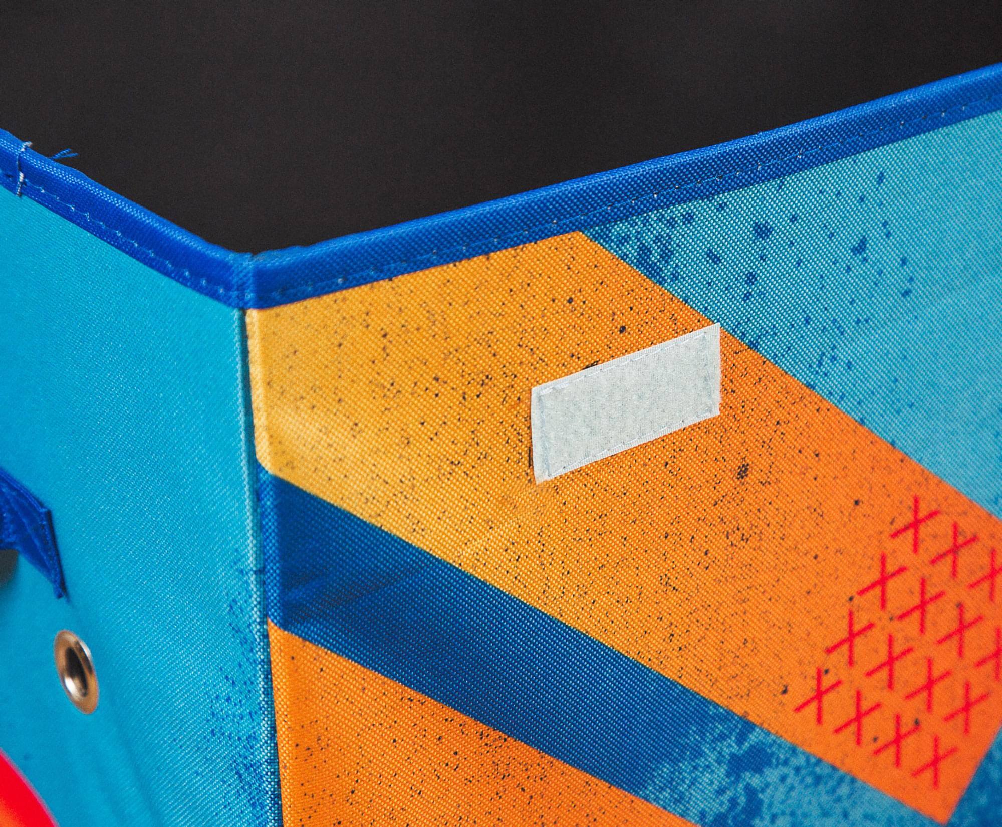 The image does not contain any text. It shows a close-up of a fabric with a blue and orange design, featuring a pattern of red crosses.