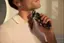 The man is using a shaving device to shave his face.