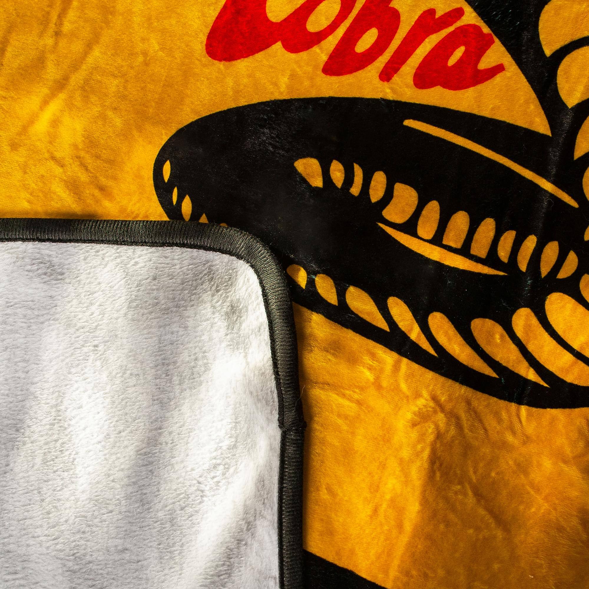 Alt View 1. Surreal Entertainment - Cobra Kai "Strike First" Fleece Throw Blanket | 45 x 60 Inches - Yellow.