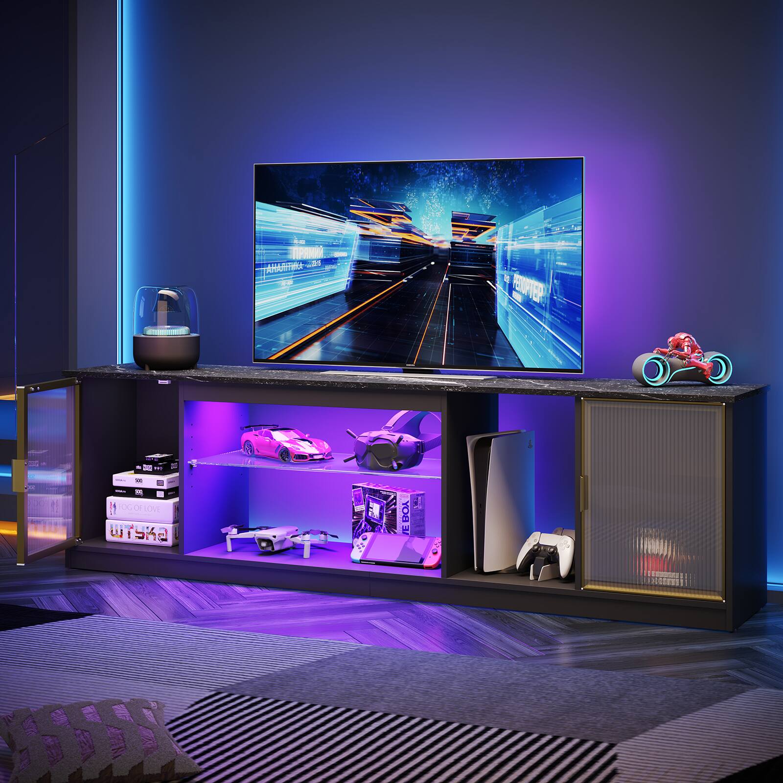 In a dark room, there is a TV on a stand with a purple glow. The TV is displaying a scene with a train. The stand also has a shelf with various items, including a remote control, a toy car, and a toy airplane. There is also a book on the shelf.