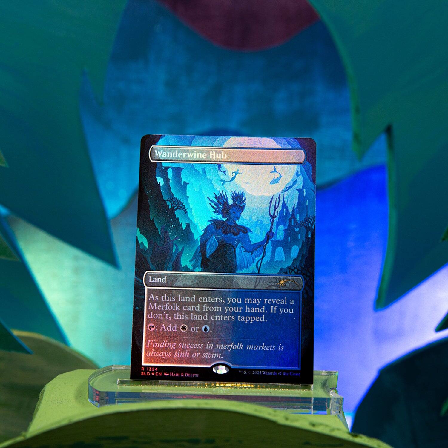 Wanderwine Hub

Land

As this land enters, you may reveal a Merfolk card from your hand. If you don't, this land enters tapped.

C: Add or O.

Finding success in merfolk markets is always sink or swim.

A 1324 SLD
EN - HARI & DEEPTI
2025 Wizards of the Coast