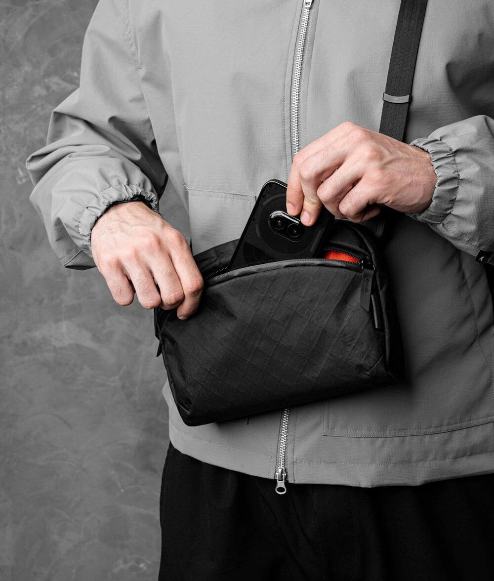 Alt View 1. ALPAKA - Flight Sling 2L Travel Sling Bag, Lightweight Packable Crossbody Pouch, Fits iPad Mini/Switch, Passport Pocket - Black Ultradyne 100D.