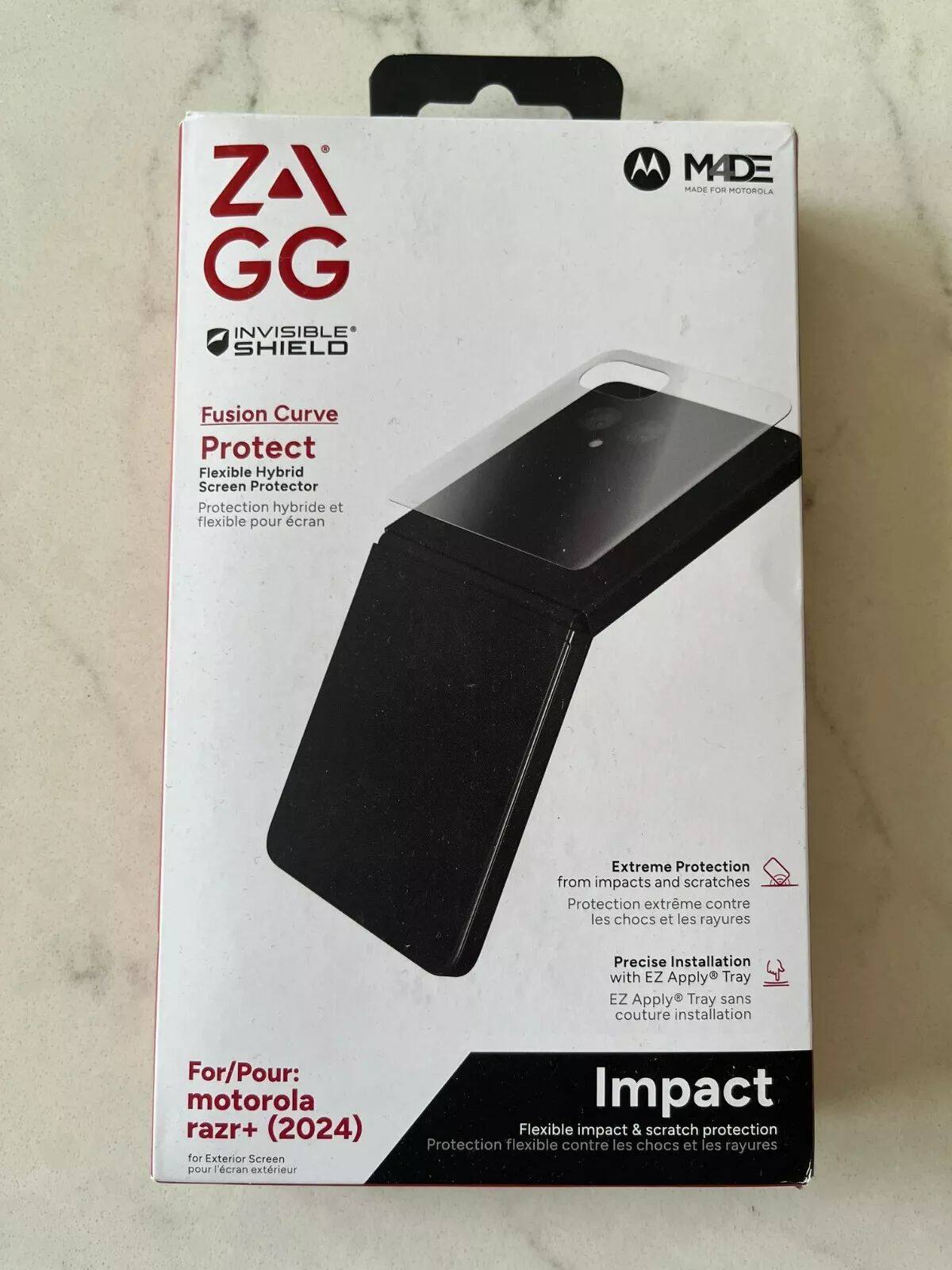 ZAGG  
INVISIBLE SHIELD  

Fusion Curve  
Protect  
Flexible Hybrid Screen Protector  
Protection hybride et flexible pour écran  

Extreme Protection from impacts and scratches  
Protection extrême contre les chocs et les rayures  

Precise Installation with EZ Apply® Tray  
EZ Apply® Tray sans couture installation  

For/Pour:  
motorola razr+ (2024)  
for Exterior Screen  
pour l'écran extérieur  

Impact  
Flexible impact & scratch protection  
Protection flexible contre les chocs et les rayures  

MADE  
MADE FOR MOTOROLA