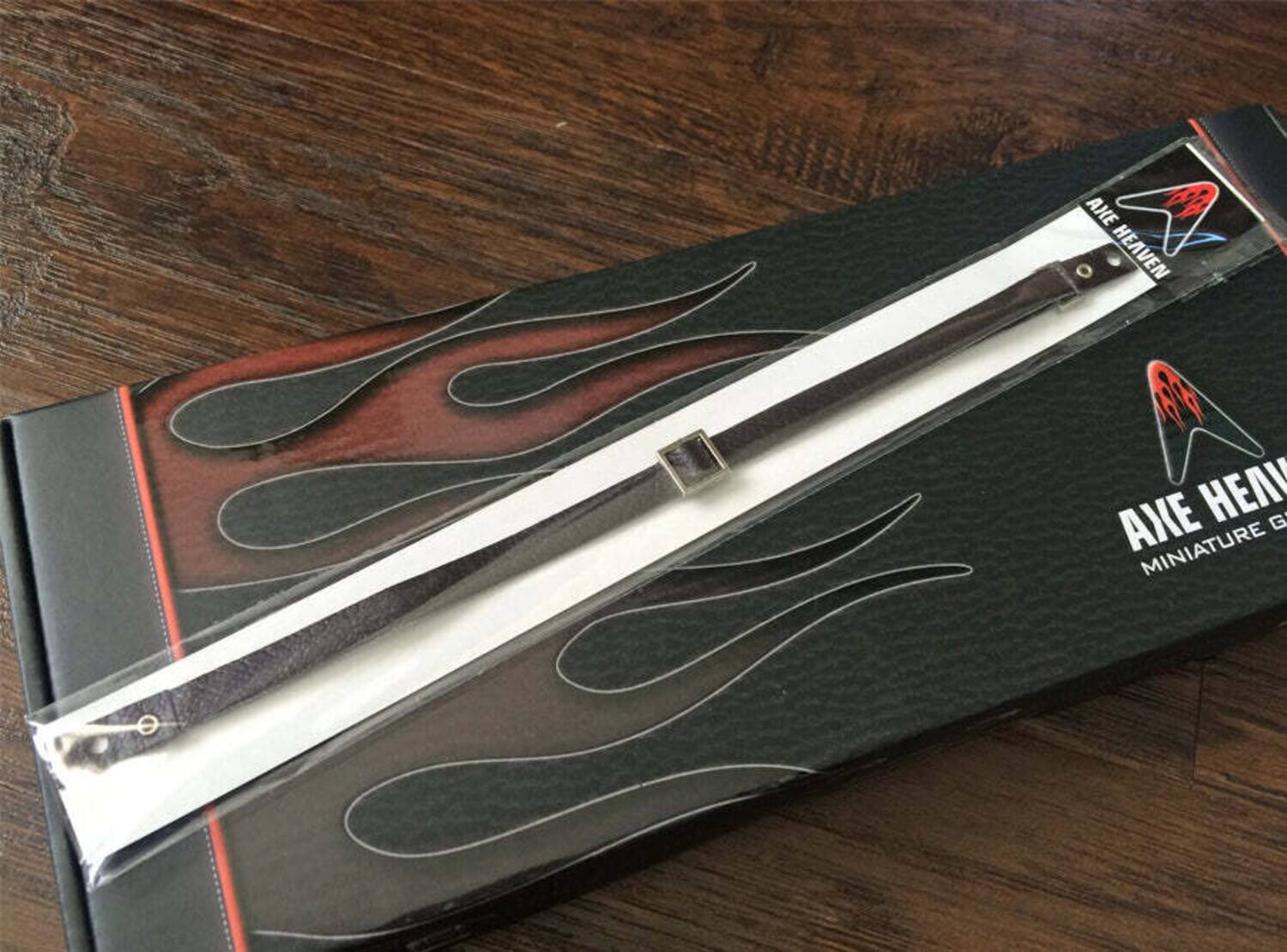 The text on the image should be grouped and corrected as follows:

"Axe Heaven Miniature G"

This appears to be a product packaging for a miniature axe.