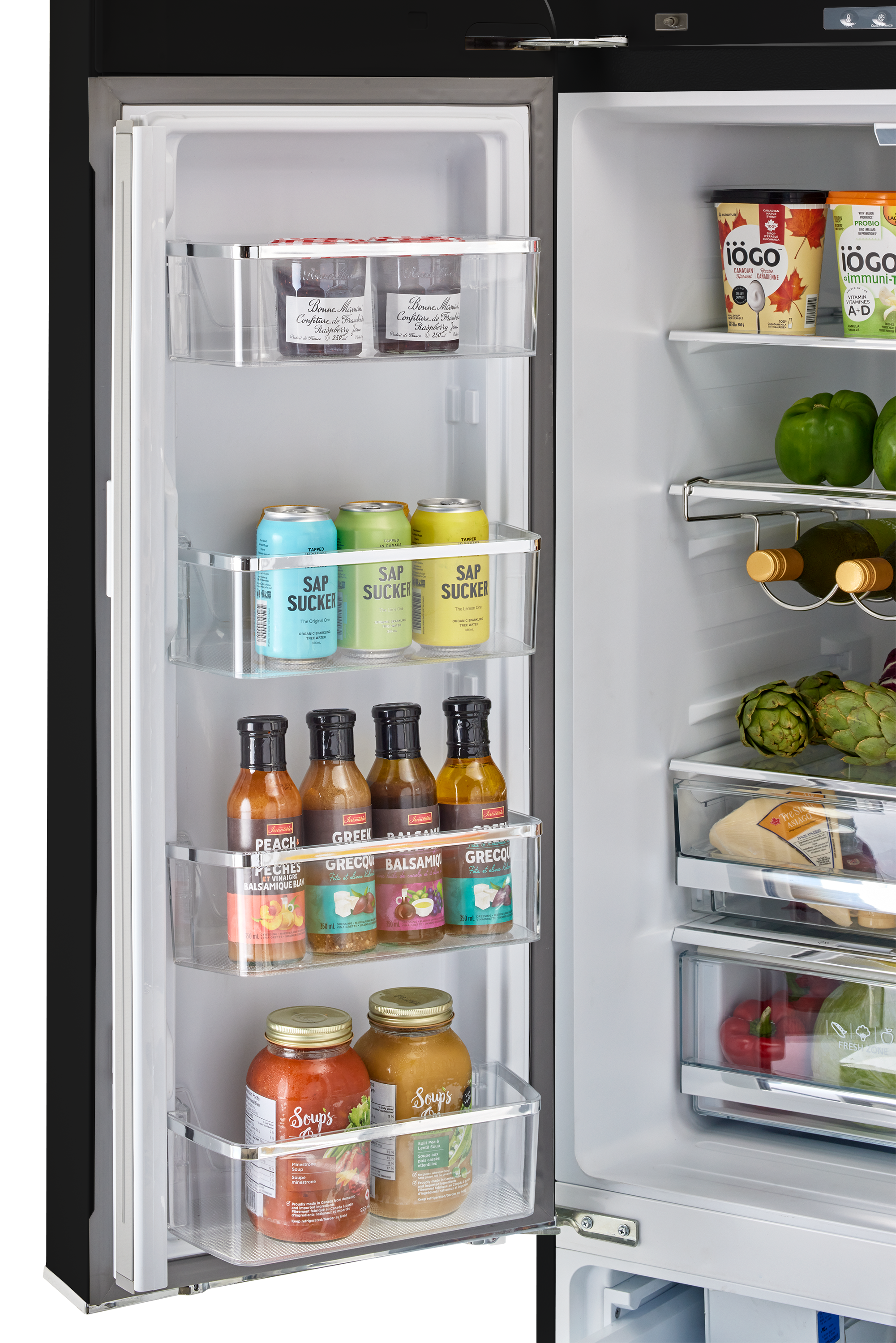 The refrigerator is stocked with various food items, including several bottles of condiments and beverages. There are multiple bottles of sauces, such as balsamic, and a few bottles of soda. The refrigerator also contains some fruits, such as apples and oranges, as well as vegetables like broccoli. The refrigerator is well-organized, with the items placed neatly in their respective compartments.