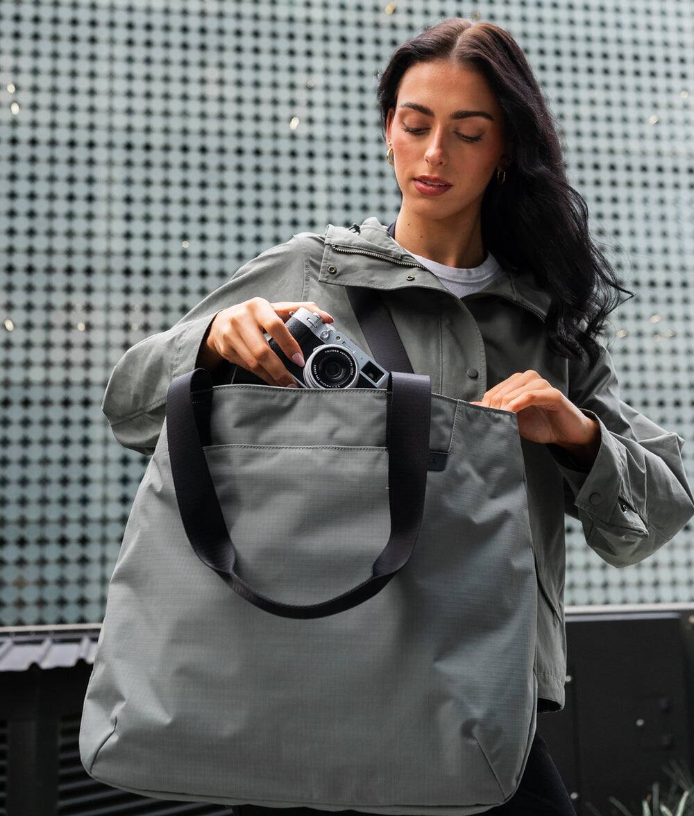 Left. ALPAKA - Elements Tote 20L Laptop Tote Bag with Padded 16" Sleeve,Open Top with Magnetic Closure - Grey Axoflux 210D.
