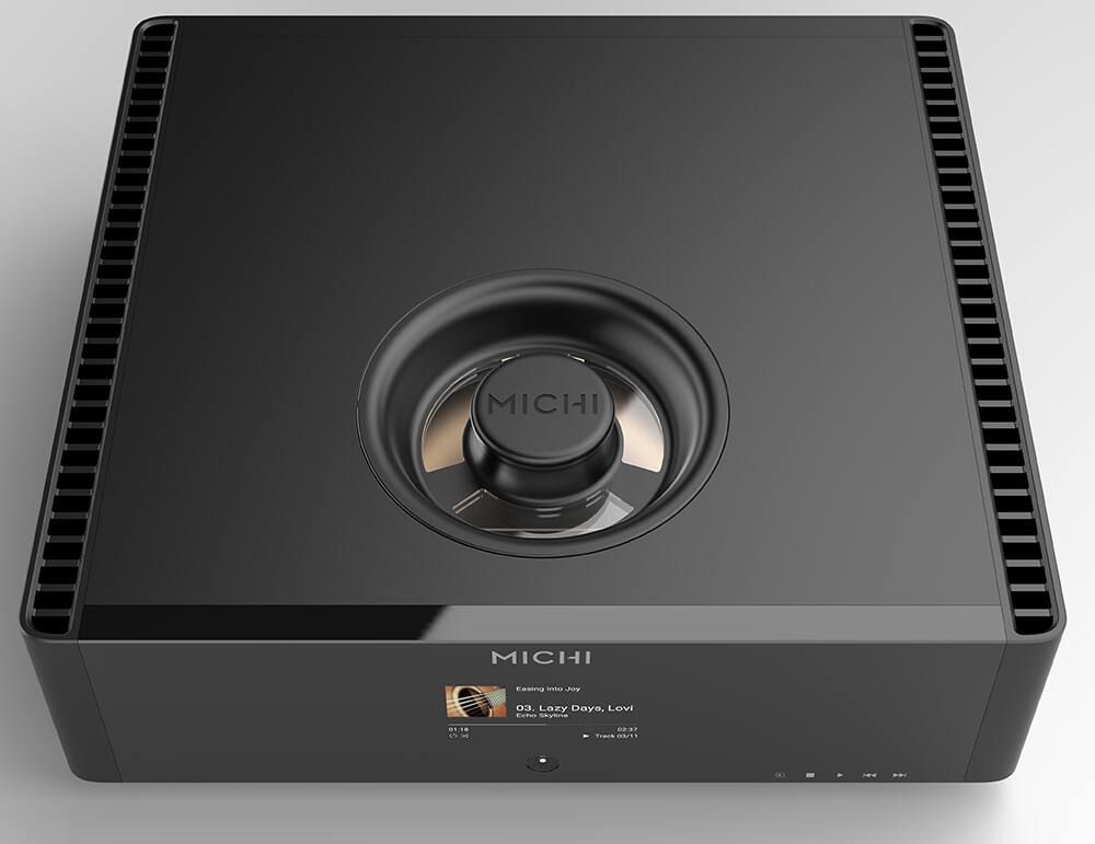 The text on the image reads "Michi Michi Casio tnt Jon 3. Lozy Dayo, Lovi Ebo SyE /8 4N m..37 TrAIS D3ES." However, it is not clear what the actual product is. It could be a speaker, a sound system, or a device with a Michi logo on it.