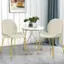 The most notable feature of the image is a small round table with two white chairs placed around it. The table has a plant on it, adding a touch of greenery to the scene. The chairs are positioned in such a way that they face each other, creating a comfortable and inviting seating arrangement. The overall setting suggests a cozy and intimate atmosphere, perfect for a casual conversation or a quiet moment of relaxation.