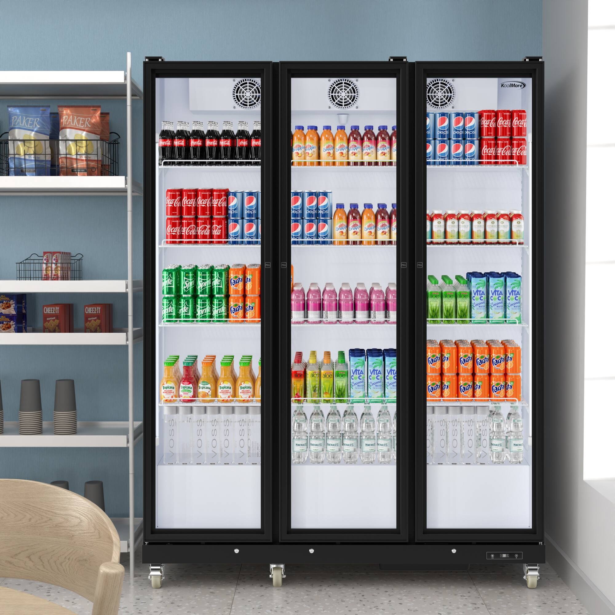 The image shows a refrigerator filled with a variety of drinks, including bottles of soda, juice, and water. The refrigerator is placed in a room with a chair nearby. The drinks are organized in the refrigerator, with some bottles placed in the door compartments and others on the shelves. The refrigerator is stocked with a wide selection of beverages, making it a convenient and accessible source of refreshments for those in the room.