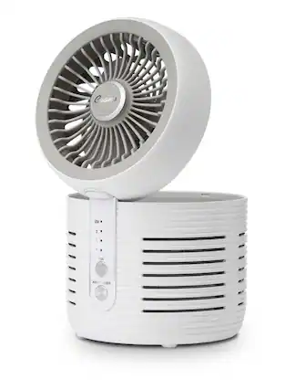 The image features a white fan air purifier with a built-in fan and a UV light. The device is designed to improve indoor air quality by removing allergens, bacteria, and viruses from the air. The fan is placed on top of the air purifier, which is sitting on a table. The overall appearance of the device is sleek and modern, making it an attractive addition to any living space.
