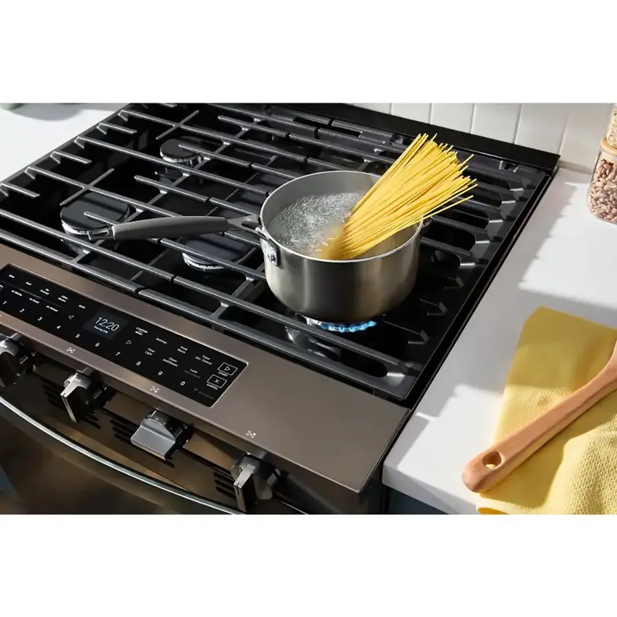 The image shows a stove with a pot of water on it. The pot is filled with noodles, and the stove is turned on. The stove has a digital display, which shows the time and temperature. The time displayed is 12:20, and the temperature is 5 F. The stove is likely being used to cook the noodles, and the pot is placed on the burner to ensure even heating. The image also features a spoon, which is likely being used to stir the noodles in the pot.